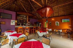 a restaurant with tables and chairs and a bar at Asamar Country Resort in Mbarara