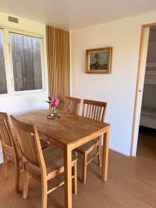 ein hölzerner Esstisch mit Stühlen und eine Vase mit Blumen in der Unterkunft Tiny House auf Pferdehof in Warendorf