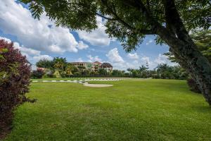 a large grassy field with a building in the background at Asamar Country Resort in Mbarara