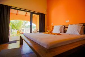 a large bed in a room with a large window at Résidence Swiss Nosy be in Nosy Be +56 photos