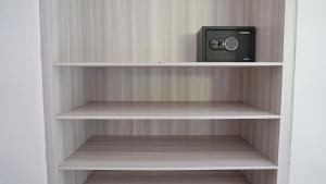 a book shelf with a clock and a radio on it at Kubu Kiku Megati in Selemadeg