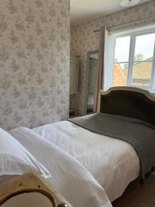 a bedroom with a bed and a window at Whichcote Arms Hotel in Sleaford