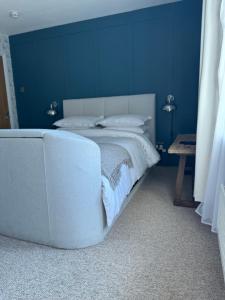 a blue bedroom with a bed and a blue wall at Whichcote Arms Hotel in Sleaford