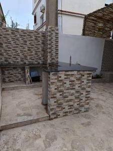 a stone counter in a courtyard with a brick wall at Skikda in Cité el ʼArbi Ben Mhîdi +3 photos