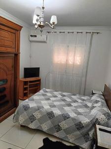 a bedroom with a bed and a window and a desk at Skikda in Cité el ʼArbi Ben Mhîdi