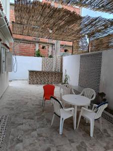 a patio with a white table and chairs at Skikda in Cité el ʼArbi Ben Mhîdi
