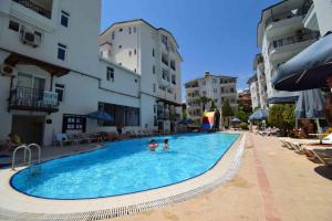 two people in a swimming pool next to buildings at Blue Garden Family Side in Side