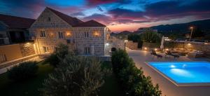 a villa with a swimming pool at night at Villa Dalma in Čilipi