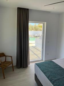 a bedroom with a bed and a sliding glass door at Ninemia Naxos Suites in Naxos Chora +69 photos