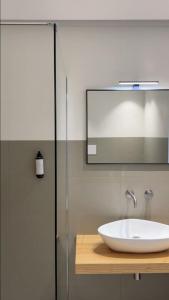 a bathroom with a white sink and a mirror at Zahir Rooms & Wellness srls in Trapani