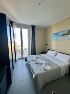 a bedroom with a bed and a large window at hotel Torretta Bramante in Rimini