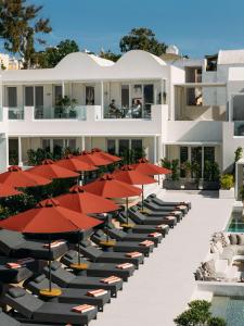 an exterior view of a hotel with tables and umbrellas at Santorini Heart Hotel & Spa in Fira