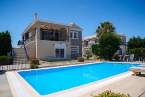 a villa with a swimming pool in front of a house at Anasa Villas in Mythimna