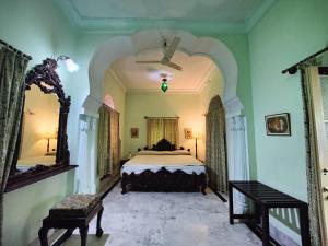 a large bedroom with a bed and a mirror at Palkiya Haveli - Heritage Hotel in Kota +19 photos