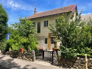 a house with a stone fence in front of it at La coopé de maurines in Maurines