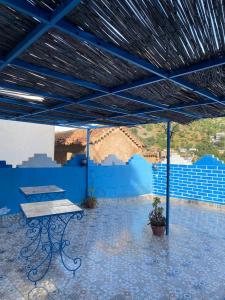 a blue wall with a bench and a table at Bleu Chefchaouen in Chefchaouen