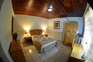1 dormitorio con cama y techo de madera en Hotel Posada Don Pantaleon, en Managua