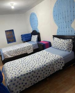 two beds in a room with blue and white at Bleu Chefchaouen in Chefchaouen