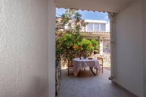 a table and chairs on a patio with a plant at Apartment Pasarela in Gajac