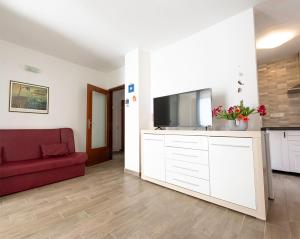 a living room with a red couch and a flat screen tv at Apartment Pasarela in Gajac