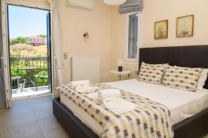 a bedroom with a large bed and a balcony at Anasa Villas in Mythimna +72 photos