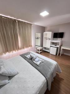 a bedroom with a large bed with towels on it at Hotel Domo in Prudentópolis +60 photos