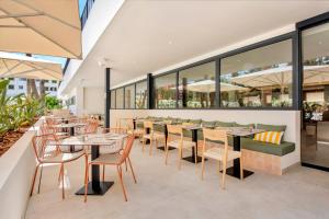 a restaurant with tables and chairs and windows at Tangerine by Honne Hotels - Adults Only in Magaluf