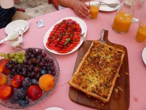 a table with a pizza and a plate of fruit at The Villa Vatikan in Trpanj