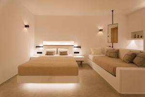 a bedroom with two beds and a couch at Ios Sea view apartment with pool 2B in Ios Chora +15 photos