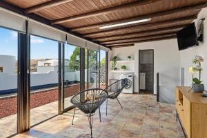 a room with two chairs and a kitchen with windows at Apartamento Guada in Tao