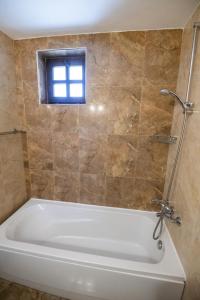 a white bath tub in a bathroom with a window at Студио in Starosel +5 photos