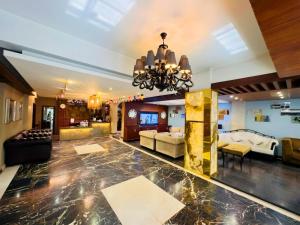 a large living room with a chandelier at Elite Hotel Airport in Dhaka