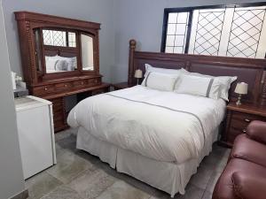 a bedroom with a large bed and a mirror at CCV Beach House in Bay View