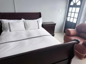 a bedroom with a bed and a chair and a window at CCV Beach House in Bay View +9 photos