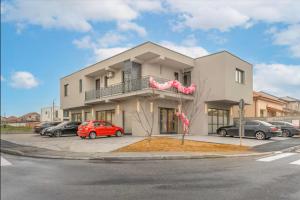 a building with cars parked in a parking lot at Art Suite - Private Parking in Oradea