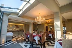 a dining room with a table and chairs and a chandelier at Elite Hotel Airport in Dhaka