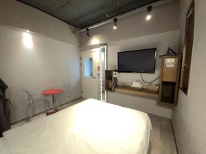 a bedroom with a bed and a flat screen tv at AREA HoTEL in Yeongju