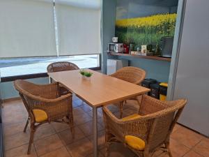 a dining room with a table and wicker chairs at Hotel Al Riu in Bagá