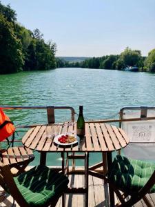 a picnic table with a bottle of wine on a boat at Houseboat - Suite Aurore in Honfleur