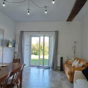 a living room with a couch and a table at Pyrenees Vue Gite - Owl - Vues Fantastique, Petit-Déjeuner, Calme, Piscine, Parking - Brand New in Saint-Gaudens
