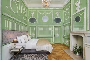 a green bedroom with a bed and a fireplace at Wyndham Grand Krakow Old Town in Krakow