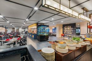 a restaurant with a counter with dishes on it at Fox Hotel Nagoya Batam in Nagoya