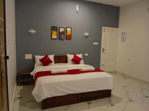 a bedroom with a large bed with red pillows at Seabay Bliss Varkala by Ojes in Varkala +6 photos