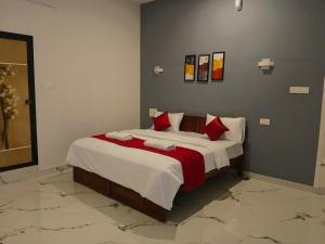 a bedroom with a large bed with red pillows at Seabay Bliss Varkala by Ojes in Varkala