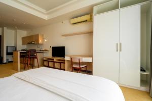 a bedroom with a white bed and a kitchen at Ceylon Vacation - Negombo in Negombo