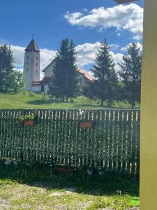 a fence in front of a farm with a silo at Aranykéz vendégház in Şoimeni
