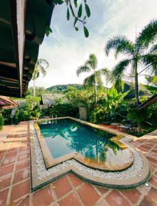 a swimming pool in a resort with palm trees at Nong Thale Garden in Ban Khao Klom