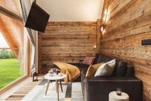 a living room with wooden walls and leather furniture at Apartament Stary Drewniany Białka Ski Resort -obok Termy Bania i Kotelnica in Białka Tatrzańska