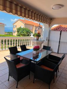 a dining room with a table and chairs on a patio at Apartment Smilja in Malinska