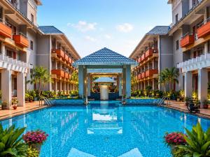 a swimming pool in the middle of a building with a gazebo at Blue Lily Beach Resort in Puri